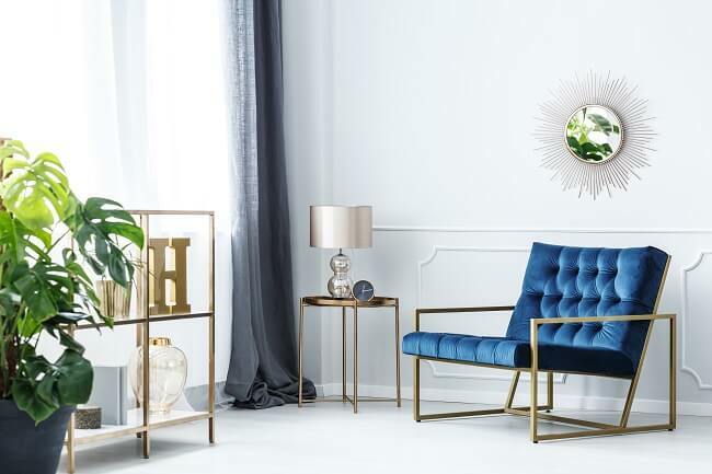 Granatowa sofa aranżacje ze złotymi elementami
