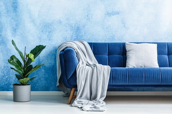 Granatowa sofa w salonie - niebieskie poduszki