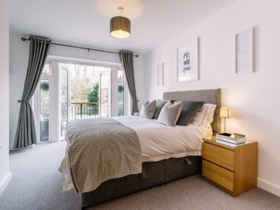 łóżko w sypialni z oknem i szafką nocną