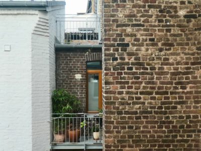 niewielki balkon z metalową balustradą